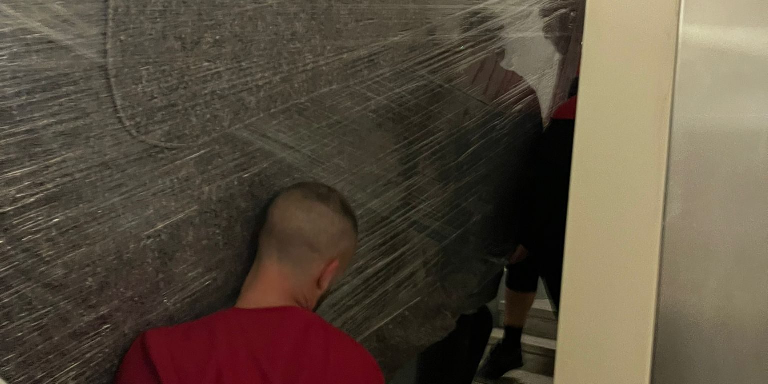 Transport verpackter Glasplatten im Stiegenhaus